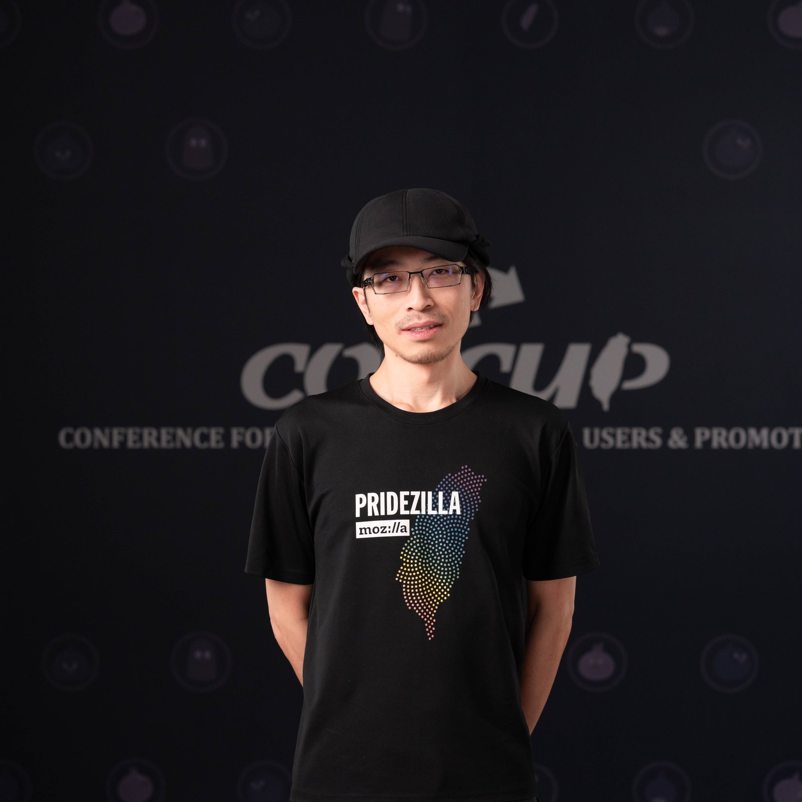 A person standing in front of a black backdrop