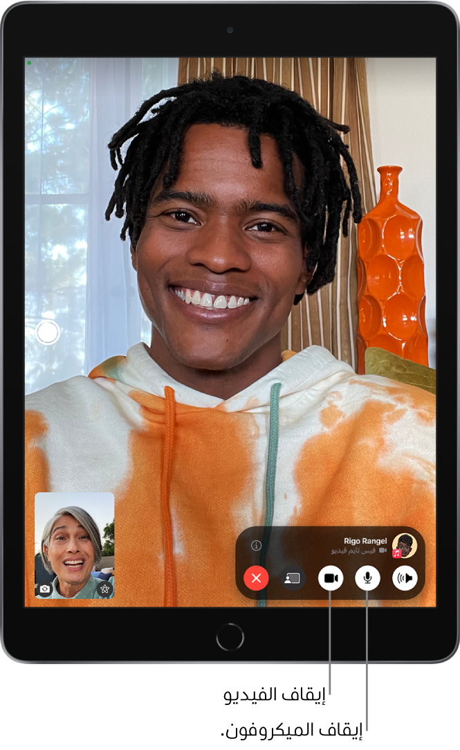 مكالمة فيس تايم قيد التقدم. تظهر صورتك في مربع صغير بالقرب من أسفل اليسار، وصورة الشخص الآخر تملء بقية الشاشة. يحتوي المربع الصغير على زري المؤثرات والتبديل إلى الكاميرا الخلفية. يوجد زر "الصورة الحية" على الجانب الأيسر من الشاشة. توجد عناصر التحكم في فيس تايم في أسفل الشاشة، بما في ذلك أزرار الصوت والميكروفون والكاميرا ومشاركة المحتوى وإنهاء. في الجزء العلوي من عناصر التحكم، يظهر الاسم أو Apple ID الخاص بالشخص الذي تتحدث إليه وزر المعلومات.