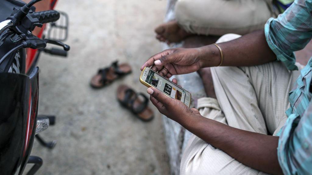 A man looks at his mobile phone in Manajipet village in the district of Gadwal, Telangana, India, on Monday, June 11, 2018.