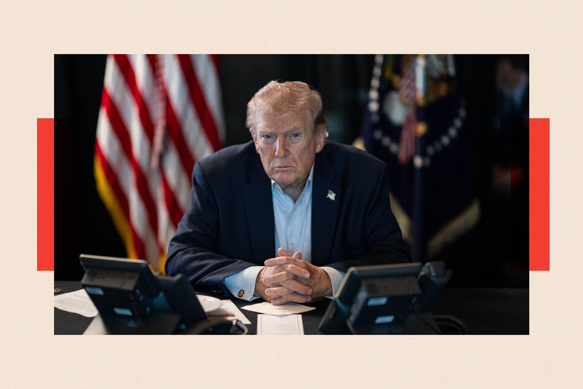 US President Donald Trump sits at a table