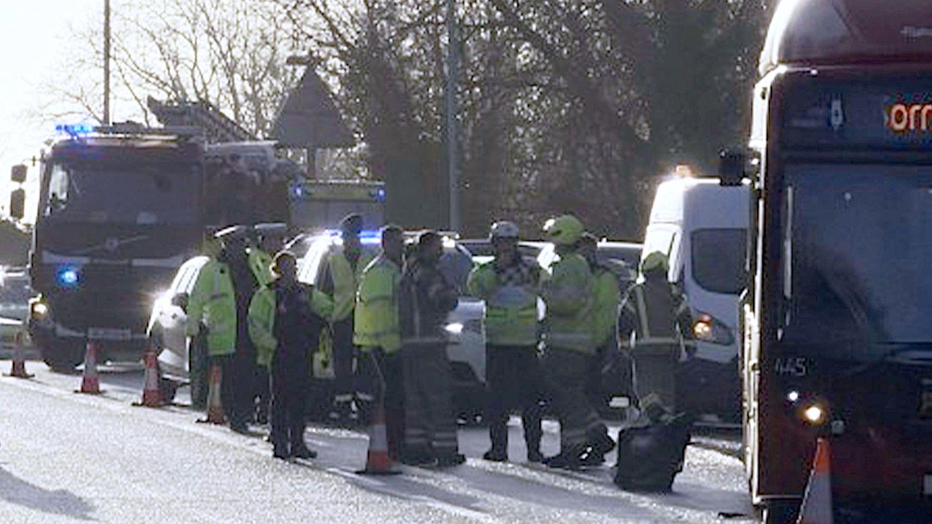 A picture of the bus and emergency services personnel, including a fire engine, on the slip road.