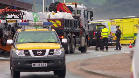 A lorry with sandbags on the back of it and a coastguard vehicle.